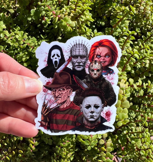 Sticker with horror movie character faces held over green foliage